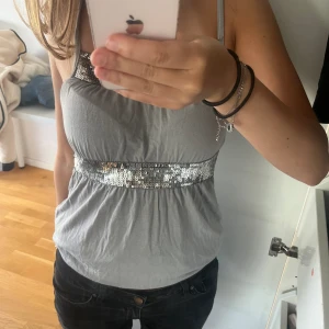 silvertopp! - Jättefint linne med fina glitterdetaljer som passar perfekt att ha som en festtopp! Kom privat för fler frågor!