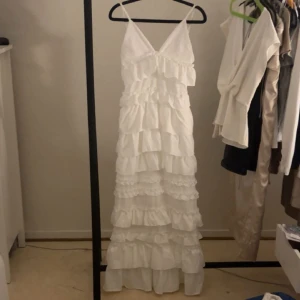 Revolve klänning💕 - En vit lång volang klänning från revolve. En äldre modell som är andvänd en gång i helt nyskick. Den är ner till marken på mig som är 160cm lång. Nypris 1600kr säljs för 800kr, vid snabbt köp 700kr.💕