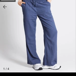 Blå byxor - Ett par blå byxor med elastisk midja och vida ben. Byxorna har en avslappnad passform och är bekväma att bära. säljer dem på fast ljusblå från lager 157