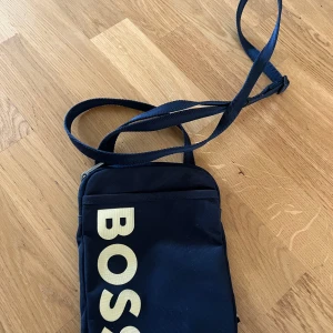 Hugo Boss Magväska - Hugo Boss Magväska. Nyskick. Sitter bekvämt. Bättre pris vid snabb affär. Köpare står för frakt