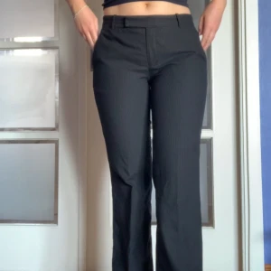 Lågmidjade randiga kostymbyxor - Kritstrecksrandiga kostymbyxor med låg midja. Storlek 38 men är insydda, skulle dock säga att de passar både 36 och 38. Bara att höra av sig för fler bilder eller frågor🩵