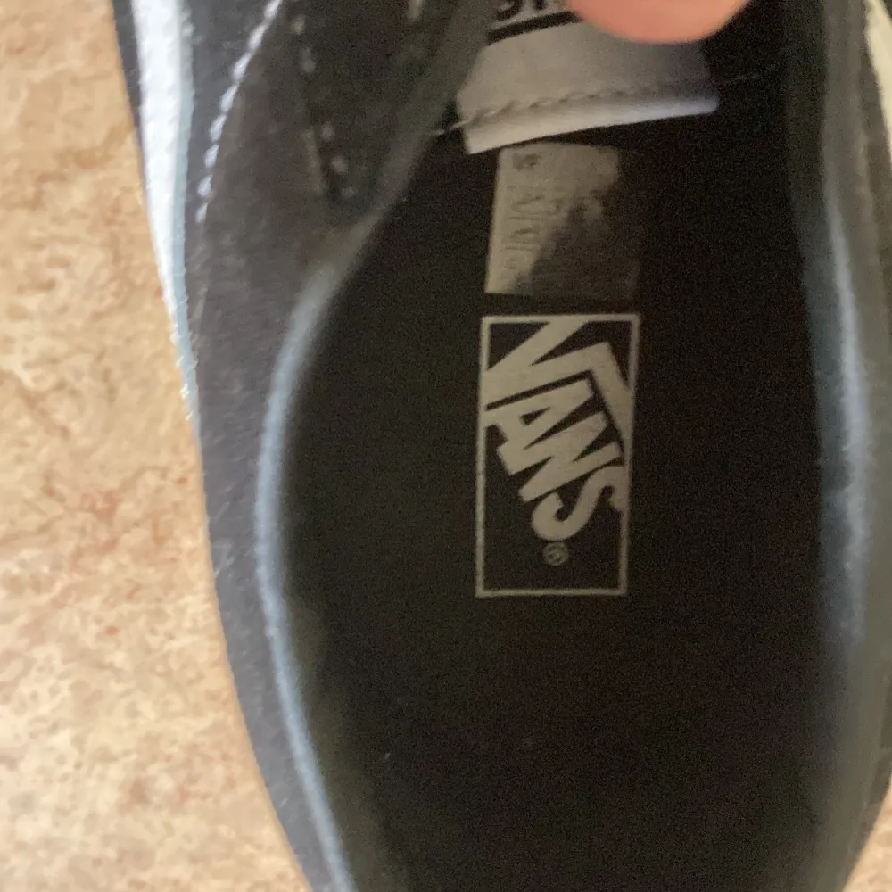 säljer mina gamla vans pågrund av att jag växte ur dom. använd typ 3 gånger.                          ett par svarta Vans sneakers med vita detaljer och snörning. Skorna har en vit sula med det klassiska rutmönstret på undersidan och en röd 'Off the Wall' logotyp på hälen. säljer mina gamla vans pågrund av att jag växte ur dom. använd typ 3 gånger.. Skor.