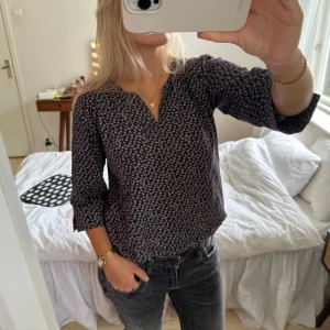 trekvartsärmad blus - trekvartsärmad mörkblå blus med vita små blommor. från märket part two copenhagen i storlek S. en liten ficka på bröstet men som inte syns särskilt mycket och slits i ärmarna 
