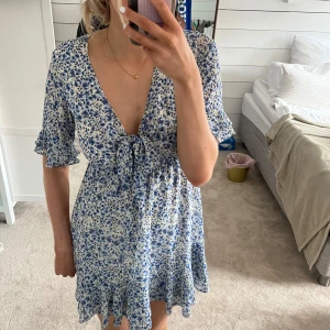 blommig klänning - Säljer en av mina favoritklänningar från NA-KD då jag tyvärr måste rensa garderoben. Den är använd Max 5 gånger så i superbra skick💖 jag är 175 för referens☺️☺️(den är köpt 2022 och finns därför ej kvar längre)