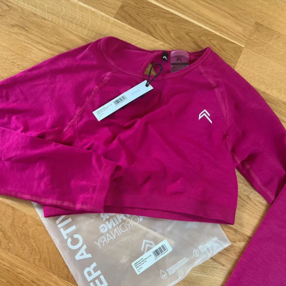 Long sleeve crop top från Oner Active i storlek M. I färgen fuchsia. Helt ny/oanvänd och inget att anmärka på. 54% polyamid, 40% polyester, 6% elastan.. Sportswear.