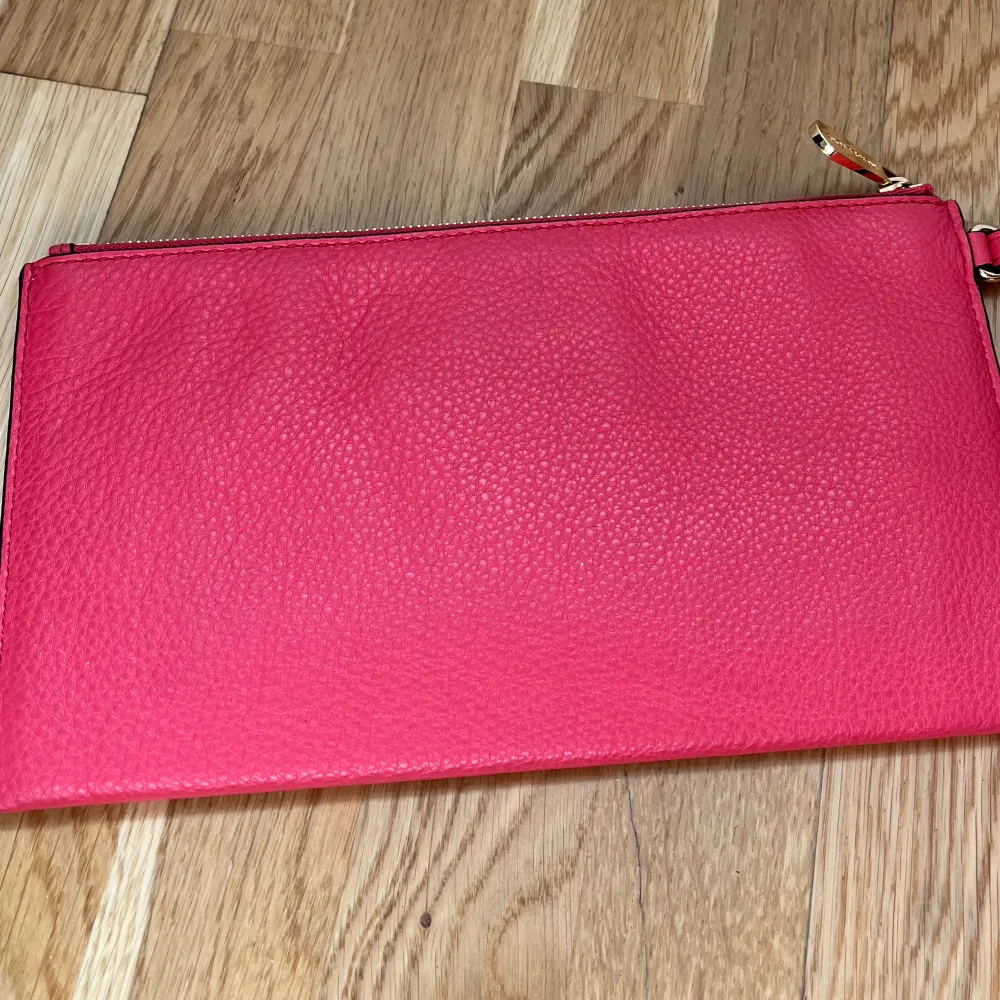 Rosa Michael Kors Clutch. Väska är köra men har dessvärre inget kvitto kvar. Har en liten fläck men annars i superfint skick. Väskor.