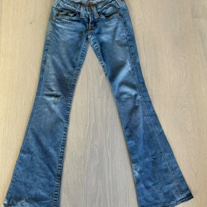 Lågmidjade bootcutjeans true religion - Säljer dessa snygga bootcut jeans från true religion i st w26 som motsvarar ungefär en xs-s  Innerbenslängden är ca 83 cm 💗 Midjemåttet är ca 37 cm rakt över 💗