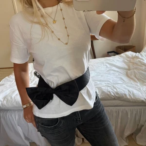 svart korsett bälte med rosett - as snyggt svart bälte med stor rosett. går att justera längden på baksidan