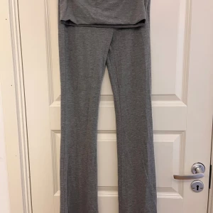 Grå mjukisbyxor - Två par grå yoga pants med låg midja och bootcut-stil. Ett par har en stjärna på rumpan. Byxorna är tillverkade i ett mjukt och bekvämt material, perfekt för avslappnade dagar.