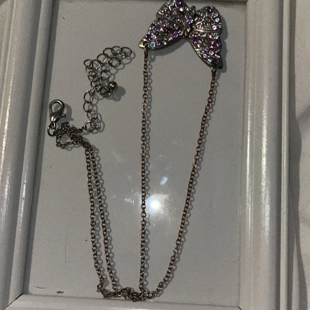 Ett fjärilsbalsband från hm. Det är lite rostigt men det kanske kan tvättas bort? Annars är det bra skick. Färg- silver och lila och rosa diamanter/inte äkta. Asusteet.
