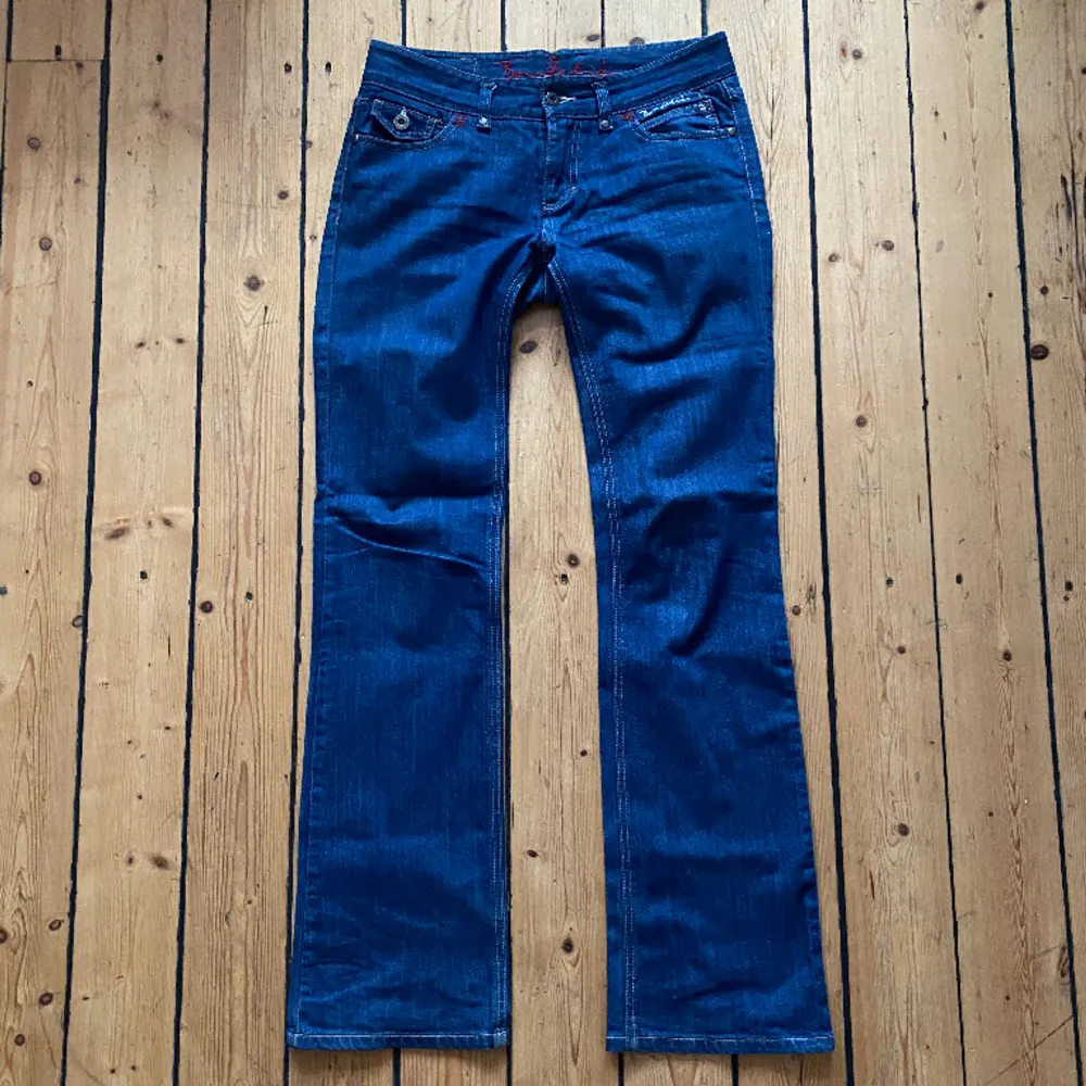 Blå lågmidjade bootcut jeans från Bondelid, så söta detaljer och sitter snyggt. Midjemått  42cm innerbenslängd 83cm. Jeans & Byxor.