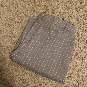 Kostymbyxor  - Gråa randiga kostymbyxor från bikbok. Byxorna är i bra skick och knappt använda.