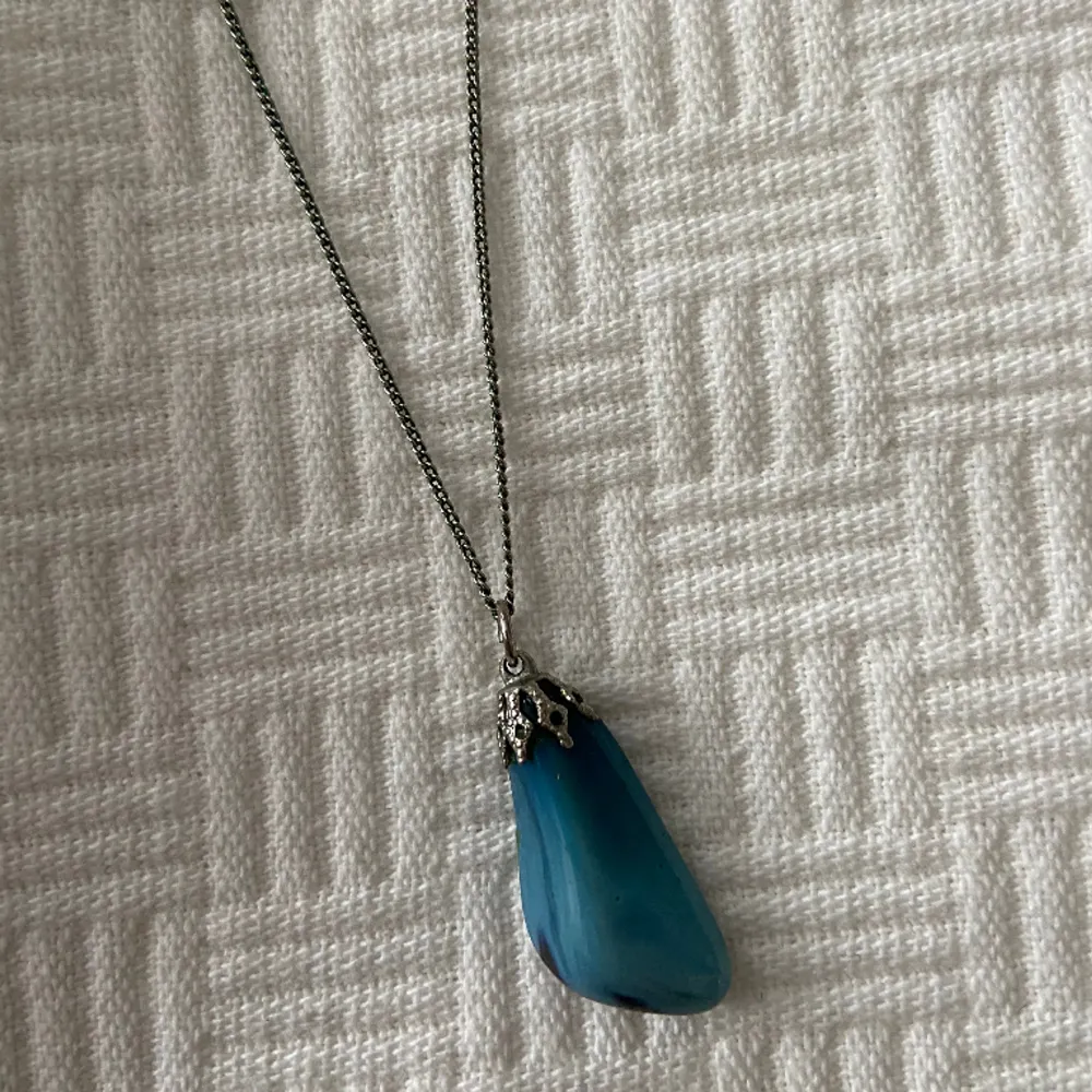 Ett halsband i silver med en blå sten 💙Är ganska säker på att det är en äkta kristall, en blå agat! Köpte den på loppis och har frågat runt lite och de flesta tror den är äkta 🥰Ingen garanti dock, riktigt snygg oavsett! Lite indie-goth stil 🖤. Accessoarer.