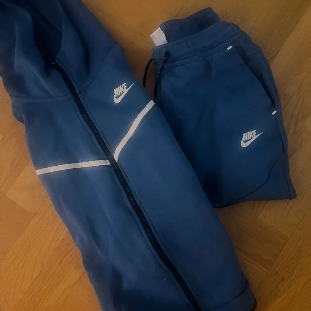 Blåa byxor blå luvtröja storlek S Nike tech.  Litet hål på tröjan fram (se bild) därav  priset. . Hoodies.