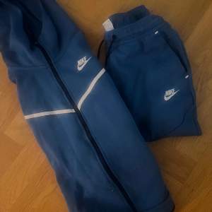 Blåa byxor blå luvtröja storlek S Nike tech.  Litet hål på tröjan fram (se bild) därav  priset. 