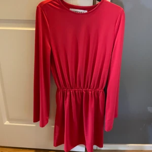 Röd klänning  - En röd klänning från Kenzas gamla märke Ivyrevel. Använd men inte de senaste åren. Har en fläck på en arm, se bild. Klänningen är tvättad men har inte använt fläckborttagning så kanske att fläcken kan försvinna då. Frakt tillkommer. 