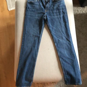 Blå jeans från Stock & Hank - Ett par blå jeans från Stock & Hank. Jeansen har en klassisk femficksdesign och en knappgylf. De är tillverkade av denim och har en läderetikett med märkesnamnet på baksidan av midjan. Jeansen är helt nya och aldrig använda. Nypris 199 säljs för 99!