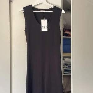 NY Zara Klänning  - NY svart klänning från Zara. Bomull. Midi / maxi längd beroende på egen längd. Figursydd modell och något utsvängd nertill.  Ursprungspris 379 kr. 