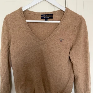 Beige/Brun Gant tröja  - En mörkare beige Gant tröja i 100% lammull. ☀️ Storlek M, något liten i storlek passar mig som är mellan S och M.  ☀️ 100% Ull - i tunnare kvalité ☀️ Använd fåtalet gånger, inga anmärkningar