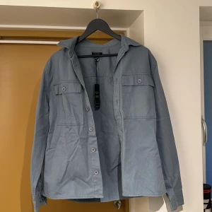 Overshirt - Overshirt från New Look. Aldrig använd och prislappen sitter kvar på. Nyskick, snygg skjorta till sommarkvällar. 