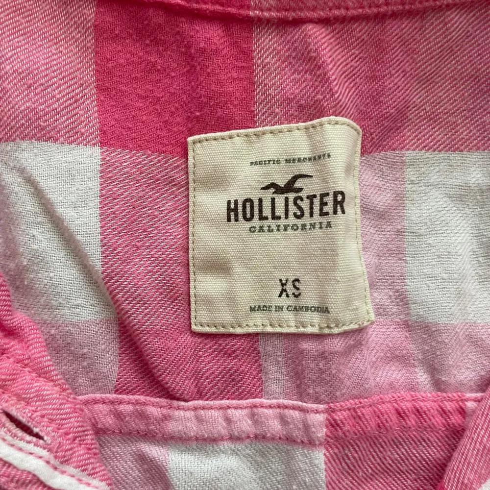 En rutig skjorta från Hollister i rosa och vit. Skjortan har långa ärmar och två bröstfickor med knappar. Den är tillverkad i bomull och har en normal passform.. Skjortor.