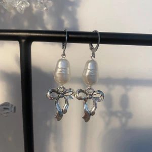 Rosett örhängen - Söta rosettörhängen med vita pärlor.🎀 finns endast 2 par! Delvis rostfria!