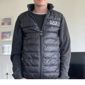 Emporio Armani Dunväst -  Säljer min snygga Emporio Armani dunväst i storlek XS för jag har växt ur den! Västen är använd men väldigt bra skick utan defekter! Nypris 1600kr, mitt pris 299:-!! Först till kvarn! 