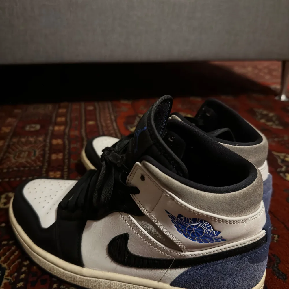 Säljer ett par Nike Air Jordans i storlek herr 40,5. Skorna är i färgerna svart, vit och blå med en snygg design. De har snörning och är i nyskick. Perfekta för både vardag och fest!. Skor.