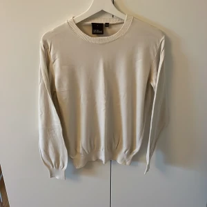 Krämvit Oscar Jacobson tröja - Fin Oscar Jacbson tunnstickad tröja i färgen Krämvit/Vit. Knappt använd, väldigt bra skick.