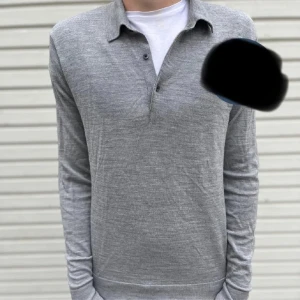 Grå långärmad pikétröja - Säljer en stilren grå långärmad pikétröja. Tröjan har en klassisk krage och knappar vid halsen. Perfekt för både vardag och lite mer uppklädda tillfällen. Den är i bra skick och väldigt bekväm att ha på sig. Passar perfekt till höst och vår.