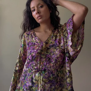 Preloved Roberto Cavalli Silk Top - Preloved Designer Roberto Cavalli V-Neck Top with Flowy Sleeves. Adjustable Drawstring at Waist. Multicolor Floral Print. Made in Italy. Hologram Label for Authenticity.  Excellent Condition.  Relaxed Fit. Best Fits M/L. Orig Tagged Size 38.