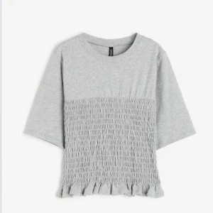 Smockad top  - Kollar intresset på min smockade top från hm som är helt slutsåld, den är i grå och är i nytt skick. Pris kan diskuteras hör av er dirket vid intresse 💕
