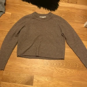 Grå croppad tröja från Zara - Säljer en superfin grå croppad tröja från Zara. Den är i storlek S och är perfekt för höst och vinter. Tröjan är långärmad och gjord av ett mjukt och bekvämt material. Den har en enkel och stilren design som passar till allt. Perfekt för både vardag och fest! 💖