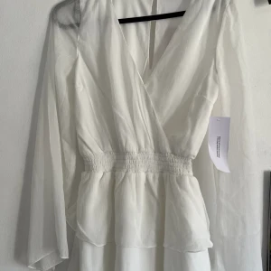 Studentklänning  - En studentklänning från Bubbleroom som aldrig använts. Långärmad med volanger. Bekväm.