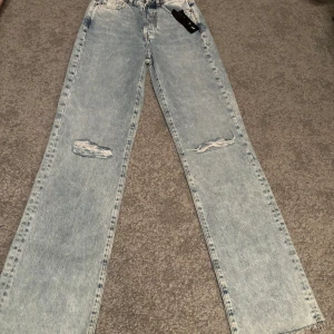 Straight jeans från Bik Bok - Jeansen har revor på knän helt oanvänd. Säljer för att de inte passar mig. Storlek 25 waist 32 length. Är 165 och längden passar med perfekt.