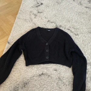 Stickad tröja  -  Svart stickad tröja med knappar på framsidan  