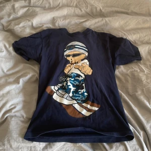 T shirt  - En fet tisha med en y2k liknande karaktär på framsidan. Bra skick. Säljer eftersom jag inte använder den längre. 