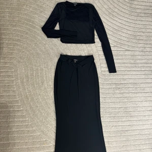 Svart set - kjol och topp - Svart set med långärmad crop top och en maxikjol med v-midja som ger kroppen en jättefin form