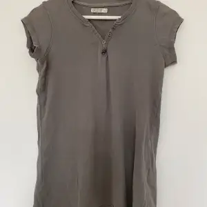 En grå t-shirt mer knappar 