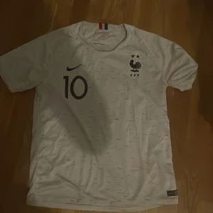Frankrike tröja - Säljer min franska fotbollströja från vm 2018. Den är i en okej skick, trycken på ryggen har gått bort lite men den ger den av en vintage look. Pris kan diskuteras