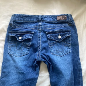 True religon  - Ett par true religon liknade jeans. Dem är bootcut och lågmidjade. Står inte storlek men skulle säga att dem är storlek 27 eftersom dem passar mig.