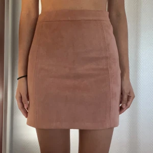 Rosa mockaimitation kjol - Superfin och skön rosa kjol i mocka-imitation. Dragkedja på sidan. Inköpt i Spanien på PULL&BEAR. Nyskick.