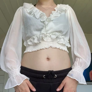 Vit blus - Jätte snygg vid blus från NA-KD i storlek 38/M. Även dom i storlek 36/S skulle kunna ha den. Har säkerhetsnål mellan brösten så man inte visar allt. Säljer då den inte kommer till användning 