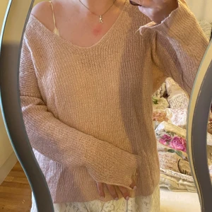 Stickad rosa - Stickad rosa tröja med glitter i garnet. Tröjan sticks lite. Finns tyvärr inga lappar kvar men jag har normalt stl 36 i tröjor. 