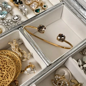 Caroline Svedbom guld armband  - Fint skick använt 5 gånger Max  Guld med en lite brun grå kristall väldigt elegant och stilrent  