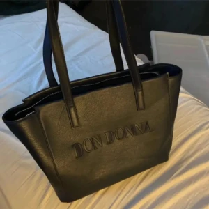 Handväska - Väska från Don Donna. Smått missformad då den legat vikt i en låda ett tag, och små smutsfläckar men inget som inte går att ta bort. Nypris ca 500kr. Hör av dig vid frågor eller intresse💗