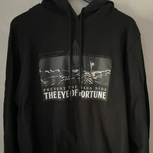 Hoodie med tryck  - En svart hoodie med tryck på framsidan från lager 157. Den har använts en del men är fortfarande i bra skick med helt tryck! Är i storlek L men skulle säga att den passar bättre som M