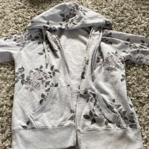 En grå collegetröja! Tröjan har fina grå rosor , men en någon liten fläck som inte går bort. Jag visar fläcken på tredje bilden. Fläcken syns knappt i verkligheten, men jag kommer ändå sälja den för billigare pris🩶🩶🩶 - Väldigt bra skick, skönt material, perfekt till sommarkvällar, storlek S🩶 Fläck=tio kronor billigare