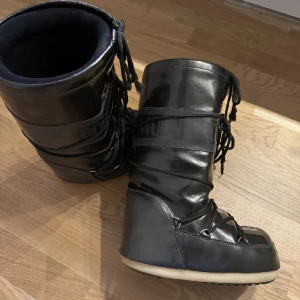 Moonboots metallic - Säljer ett par jättefina moonboots, varsamt använda och en ovanlig svart färg! Storlek 35-38! 