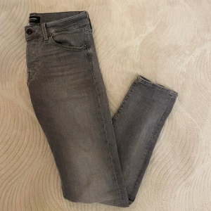 Grå Jack&Jones jeans - Säljer nu dessa riktigt feta och underskattade jeansen från Jack&Jones som är i grymt skick. Modellen är slim och storleken är 30/32! Referens- killen på bilden är 180 cm lång och väger 63kg! Hör gärna av dig vid frågor eller funderingar😃